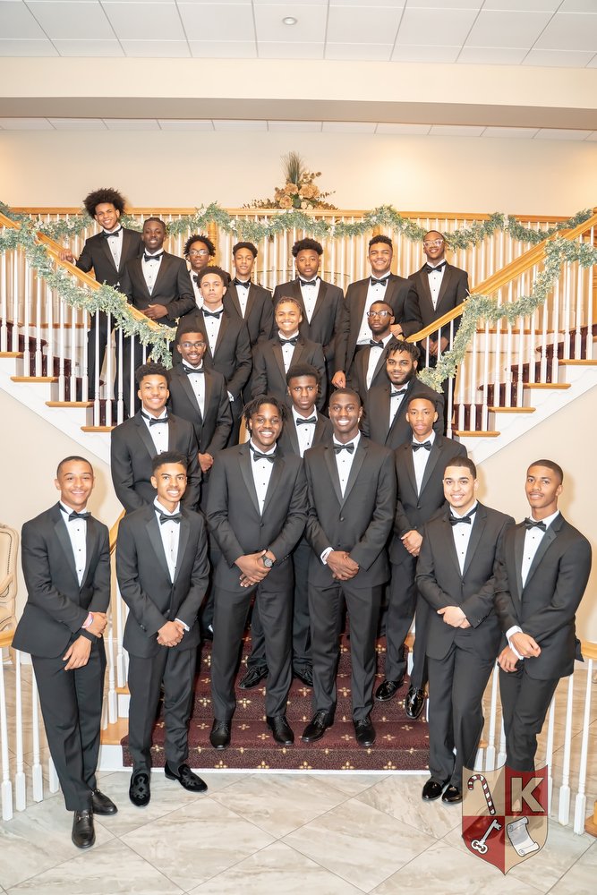Beautillion Leadership Academy participants gathered together in tuxedos on a staircase
